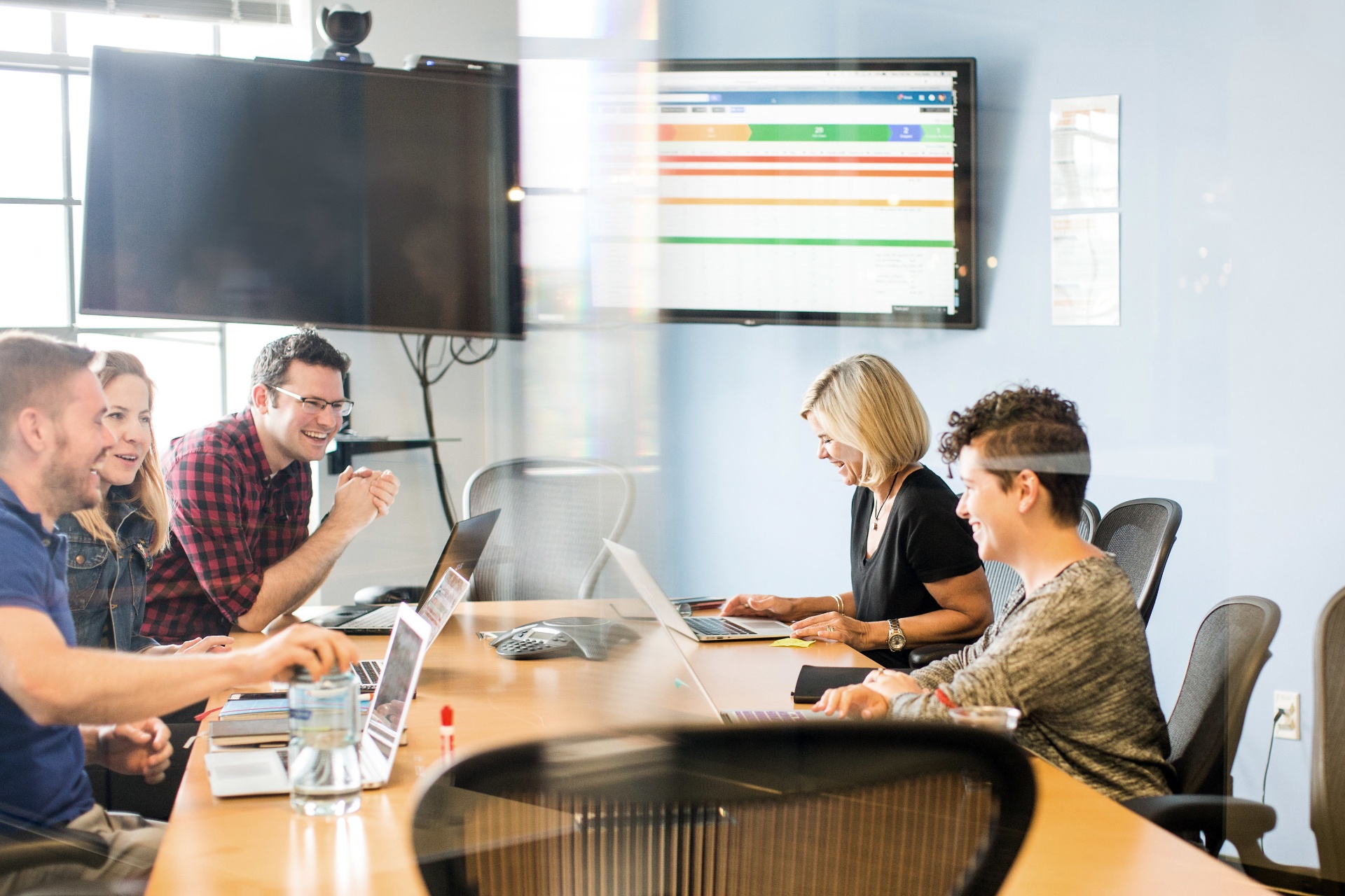 A team laughing during a meeting in a CIC conference room